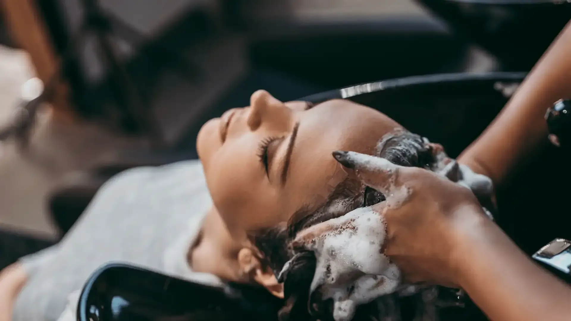 a woman is getting her hair washed at a salon