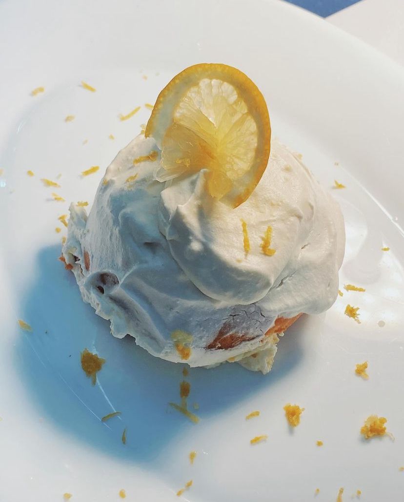 Un piatto bianco con panna montata e una fetta di limone