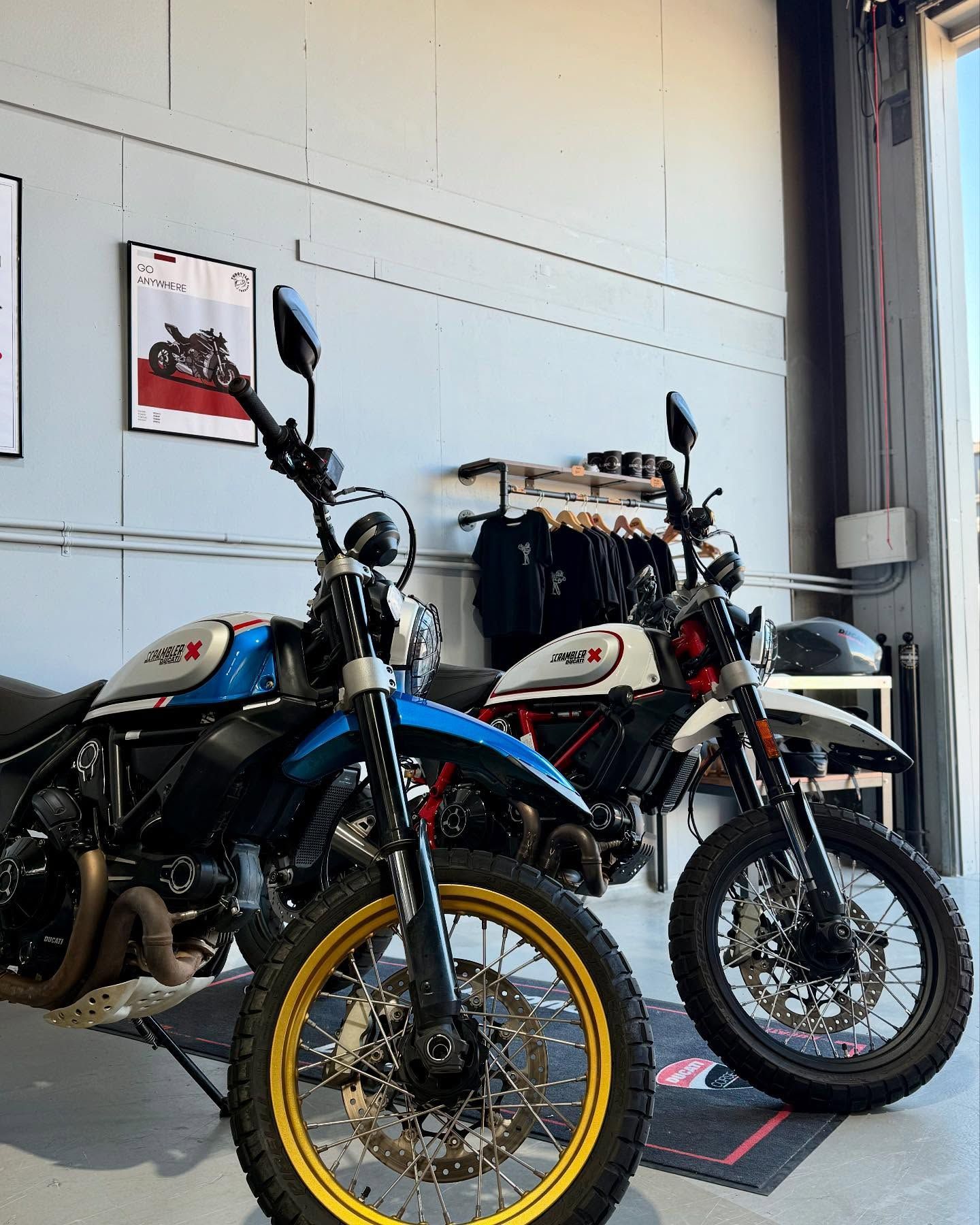 Two Ducati Scramblers side by side in the doorway of the DUC LAB workshop.