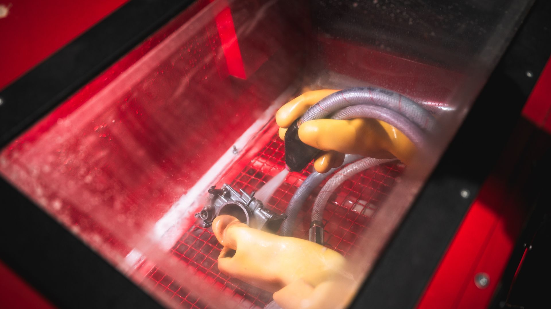 A motorcycle component is getting vapour blasted to remove rust, paint and grime.