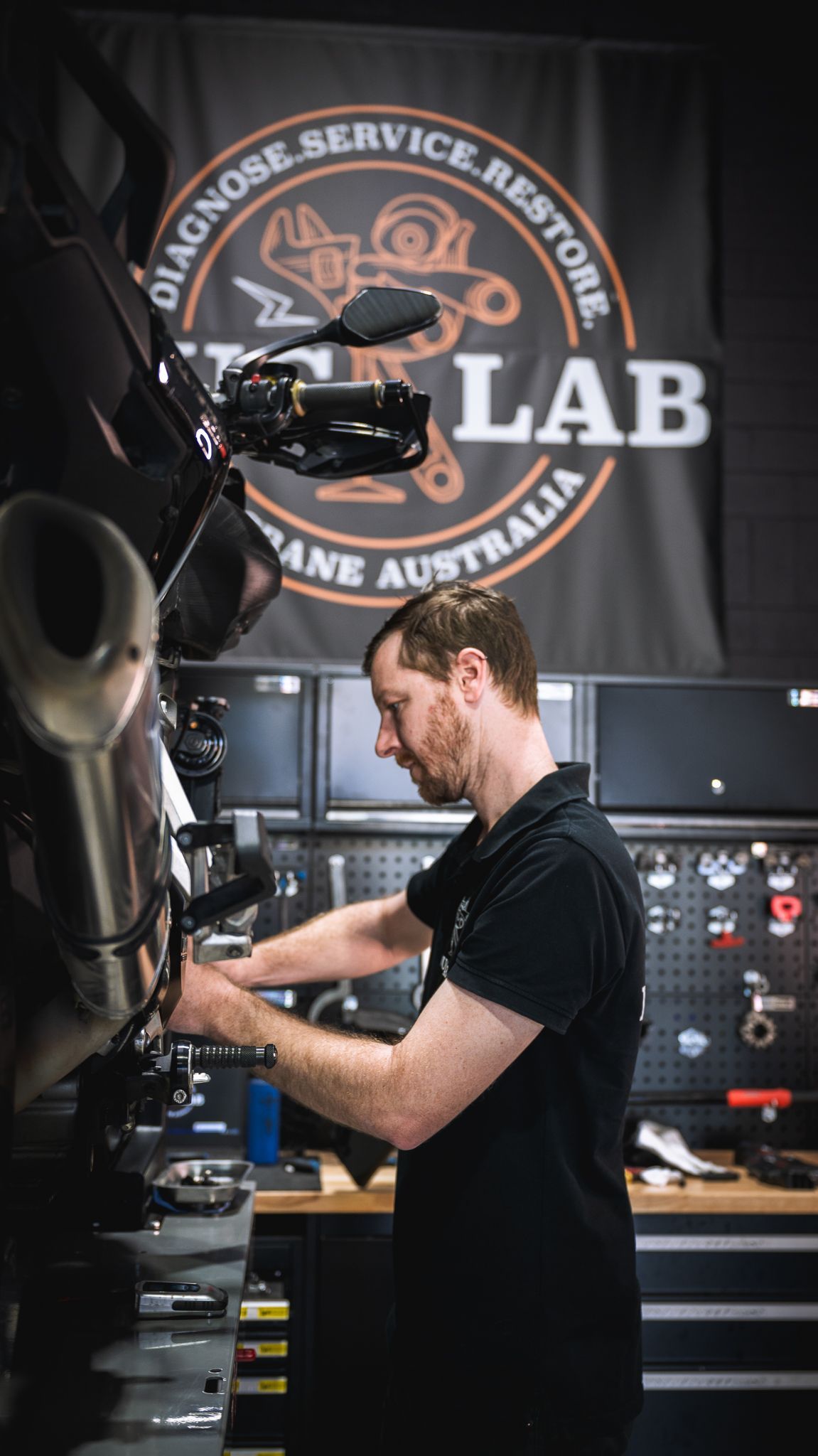 A Ducati technician is performing repairs on a motorcycle.