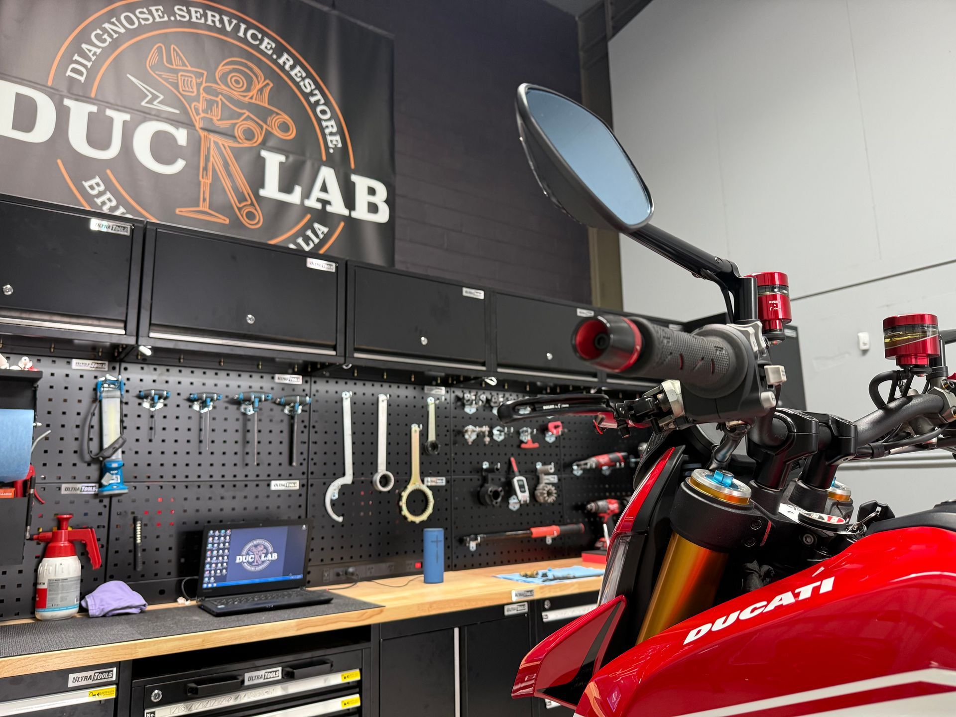 A Ducati Hypermotard on the workshop bench at DUC LAB.