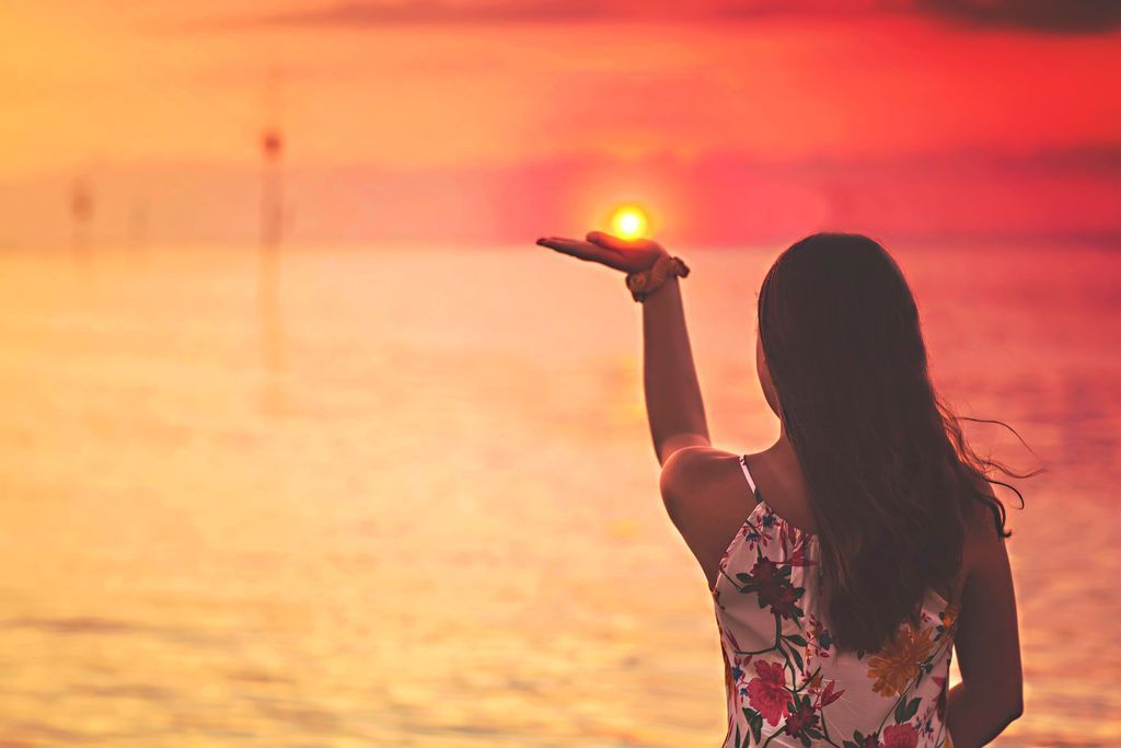 Grandparents with two grandchildren smiling outdoors in a grassy area.