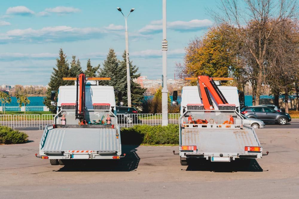 Two Tow Trucks Are Parked Next to Each Other in a Parking Lot — Southern Cross Tilt Trays in Whitsundays, QLD