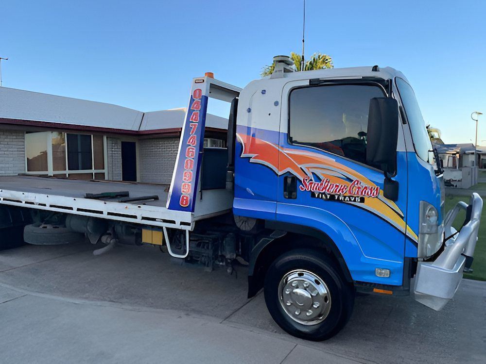 A Blue Tow Truck is Parked in Front of a House — Southern Cross Tilt Trays in Andergrove, QLD