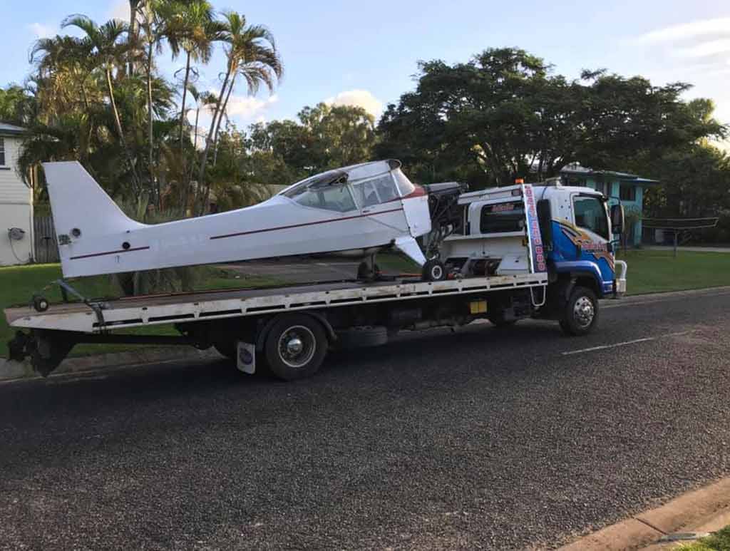 A Small Plane is Being Towed by a Tow Truck — Southern Cross Tilt Trays in Andergrove, QLD