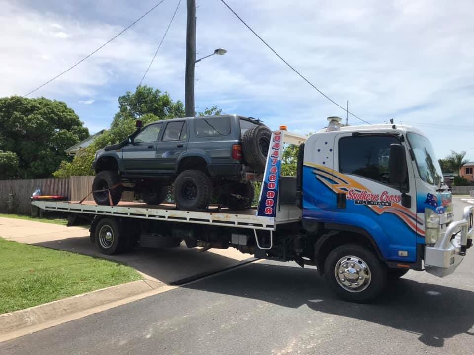 A Tow Truck is Carrying a Car on the Back of It — Southern Cross Tilt Trays in Andergrove, QLD