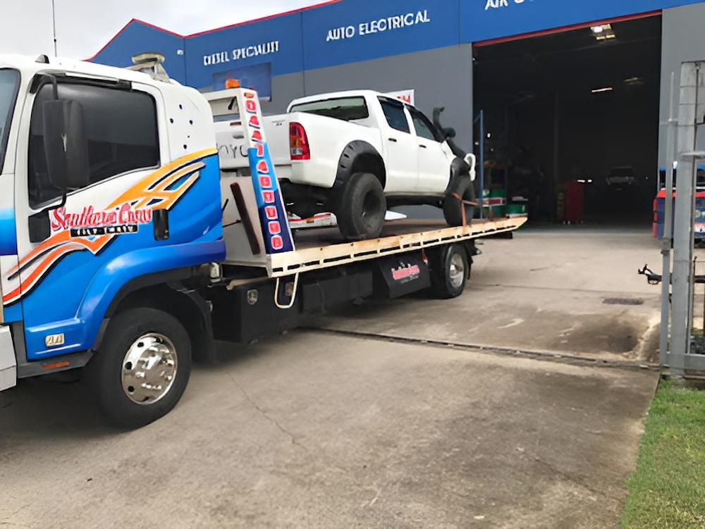 A White Truck is Being Towed by a Tow Truck — Southern Cross Tilt Trays in Peak Downs, QLD