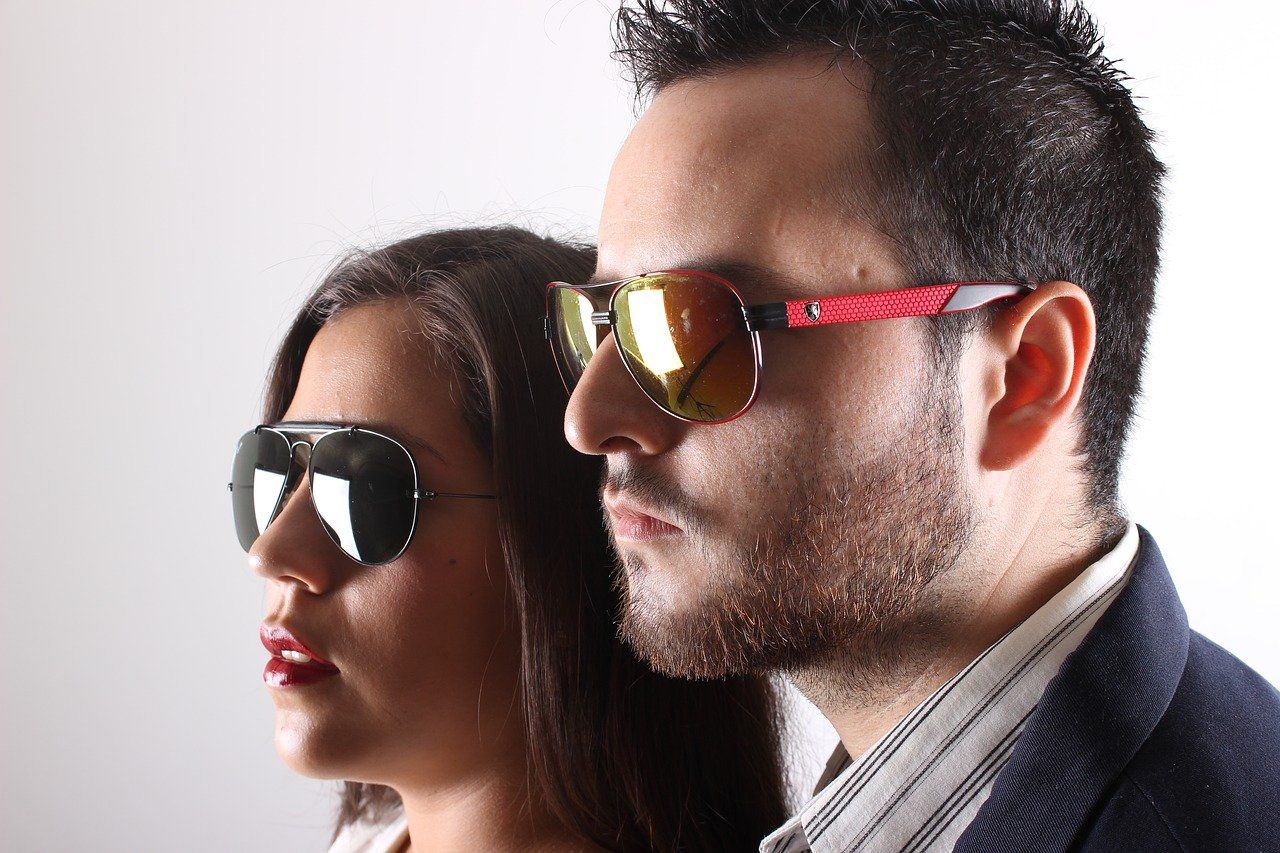 A man and a woman wearing sunglasses are standing next to each other