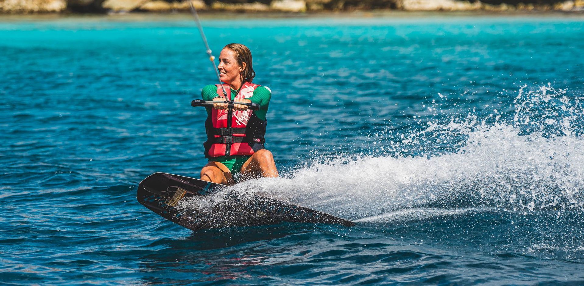 Blue Bay Bonaire Verhuur motorboten, jonge vrouw doet aan wakeboarden.