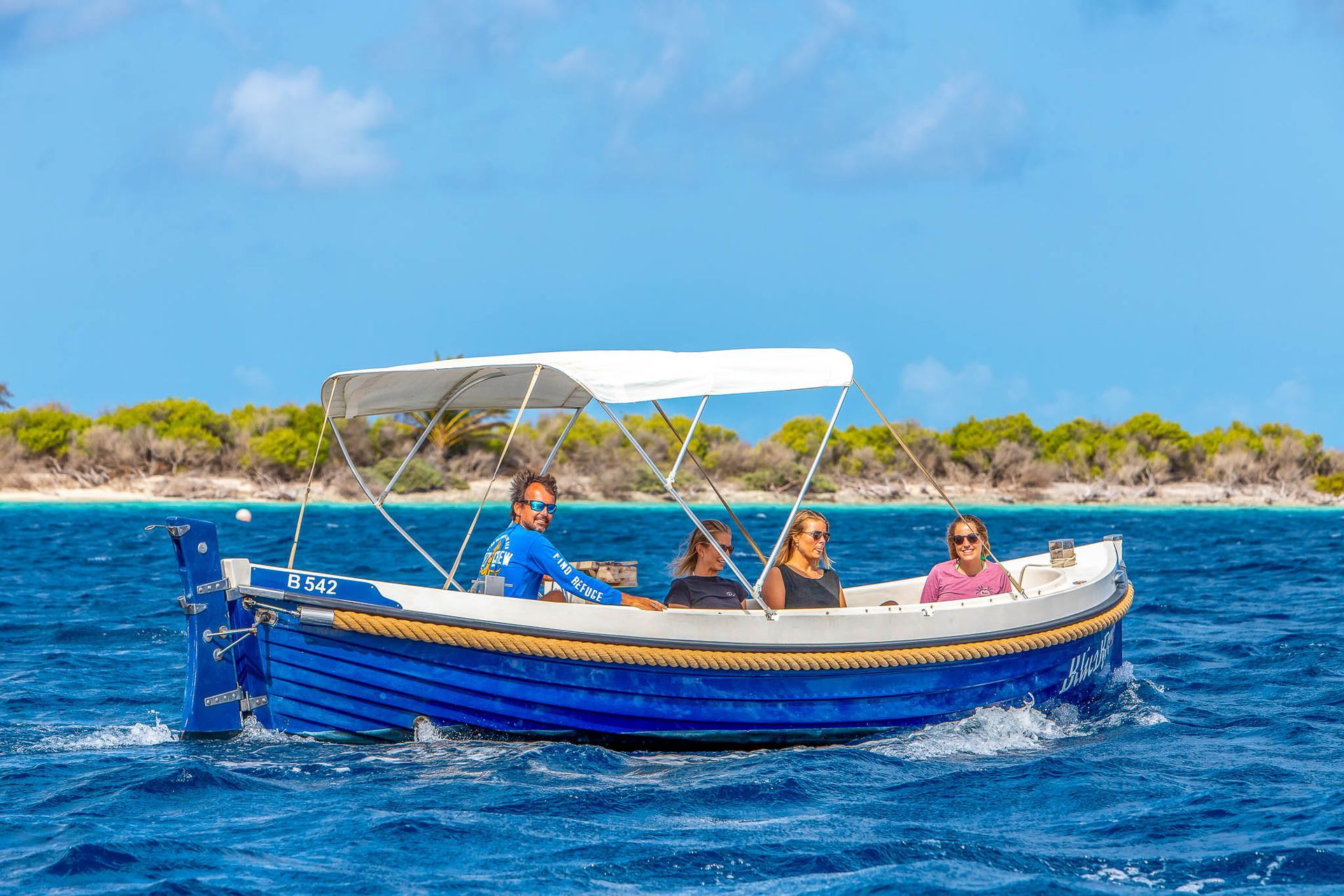 motorboat from Blue Bay Bonaire Rentals is cruising on blue Caribbean Sea to Klein Bonaire.