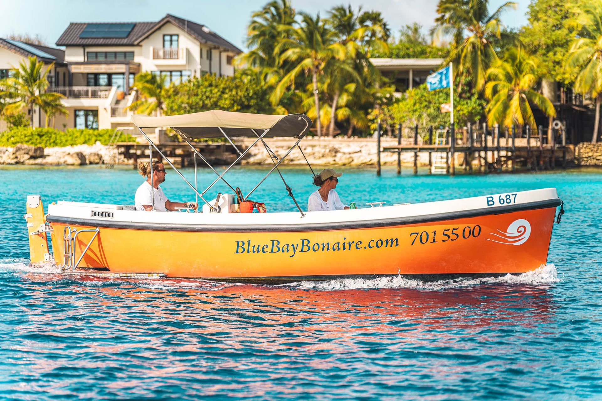 Motor Boat Orange Rental Bonaire Blue Bay is cruising along the coast of Bonaire.