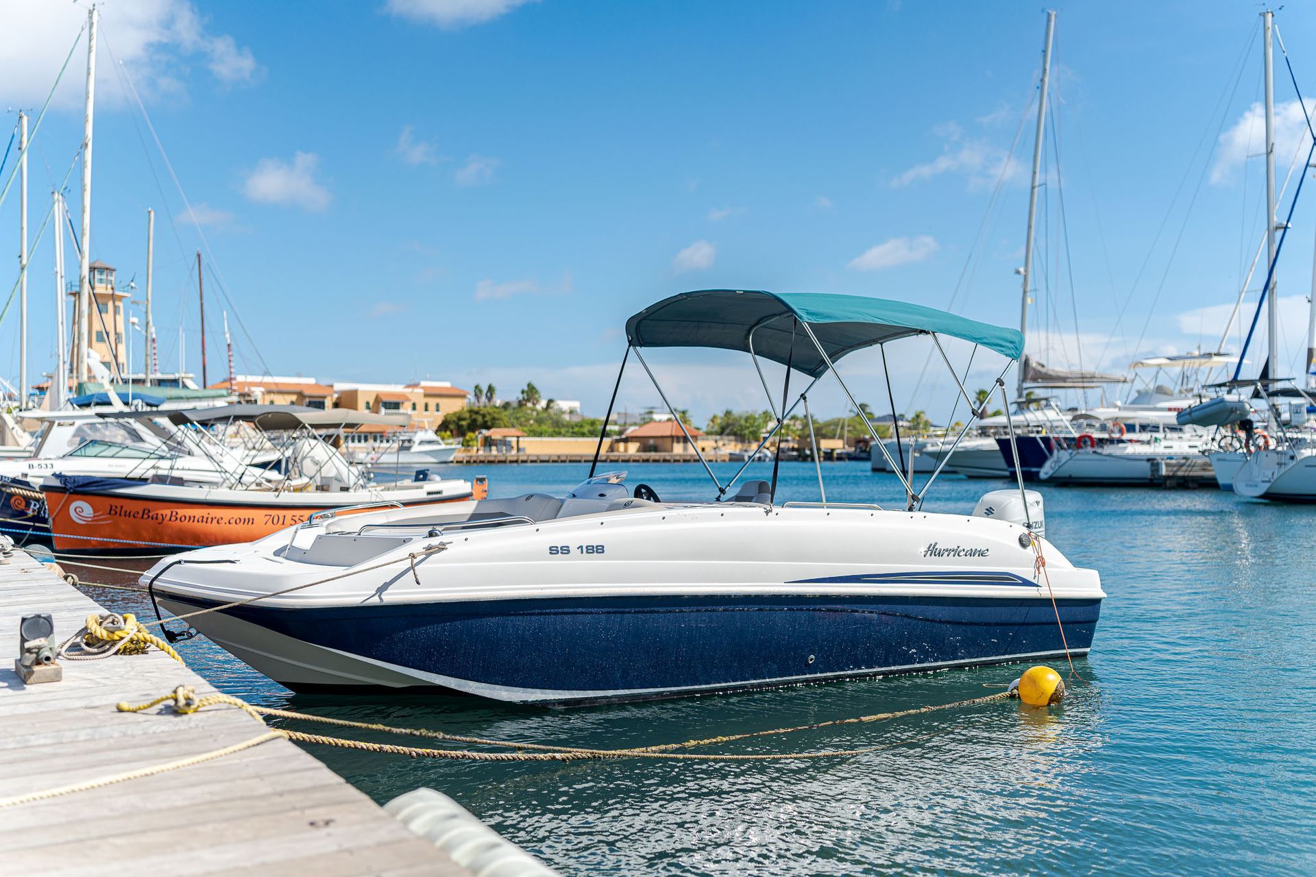 Blue Bay Bonaire Boat Rental Betty Boop Motorboat cruising on light blue caribbean sea.