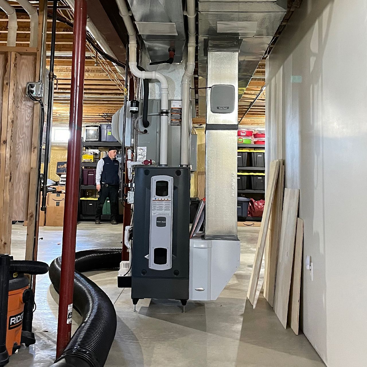 The Gorjanc Home Services vacuum hose reaching ductwork on far side of the basement.