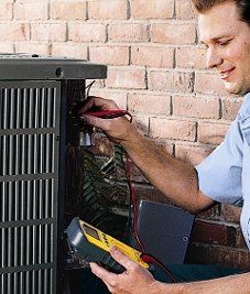 A man is working on an air conditioner with a multimeter.