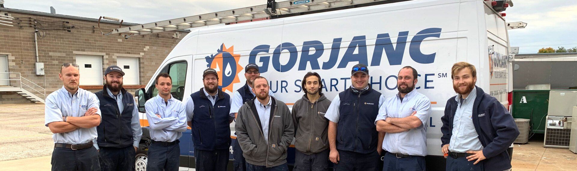 A group of men standing in front of a gorjanc truck