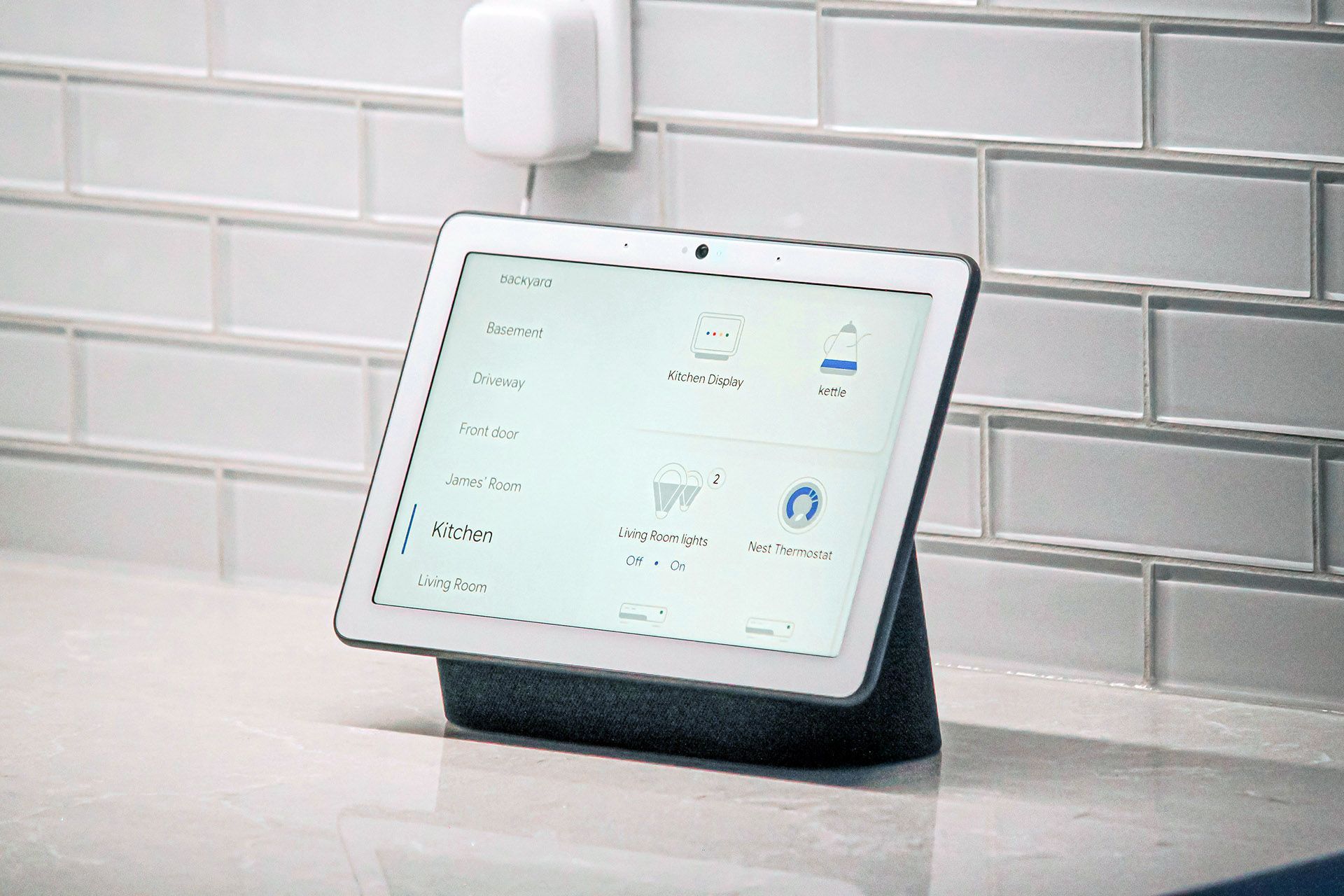 A tablet is sitting on a counter next to a brick wall.