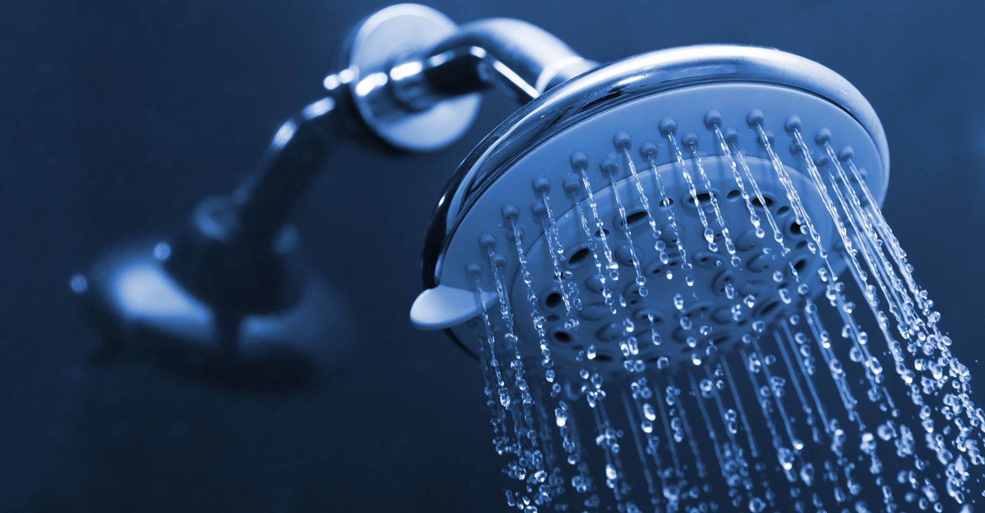 A close up of a shower head with water coming out of it.