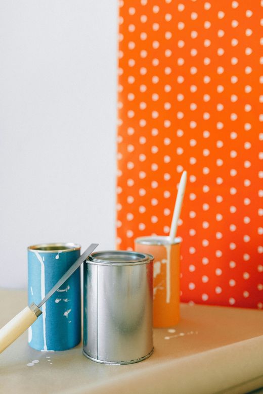 Two cans of paint and a brush on a table