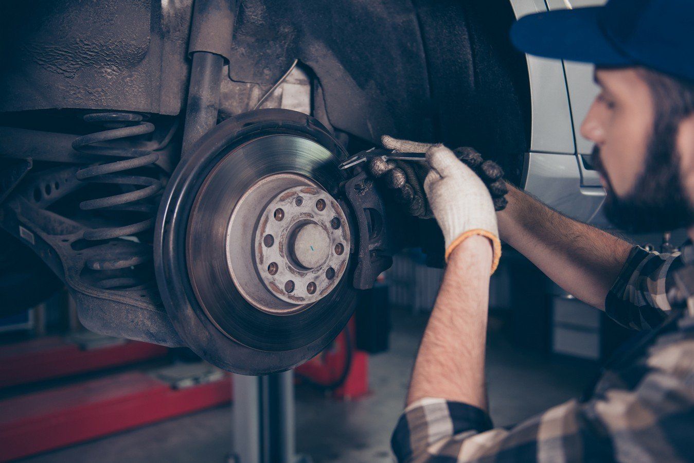 Vehicle Suspension — Technician Checking Brake Pads of Lifted up Car in Chico, CA