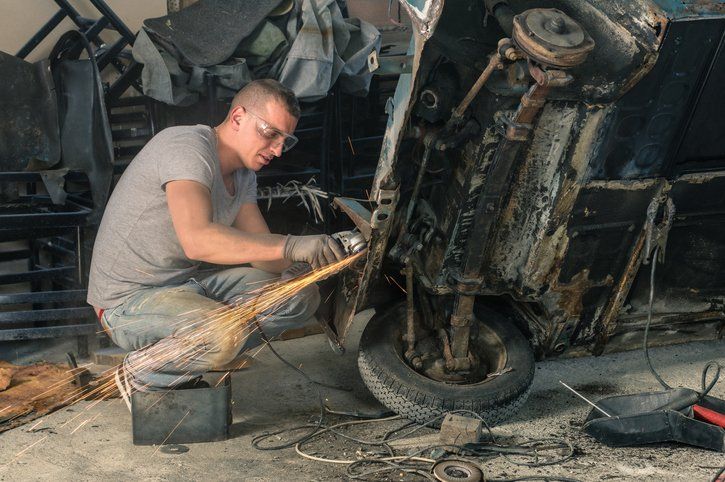 Frame Off Restoration — Worker Repairing an Old Vintage Car in Chico, CA