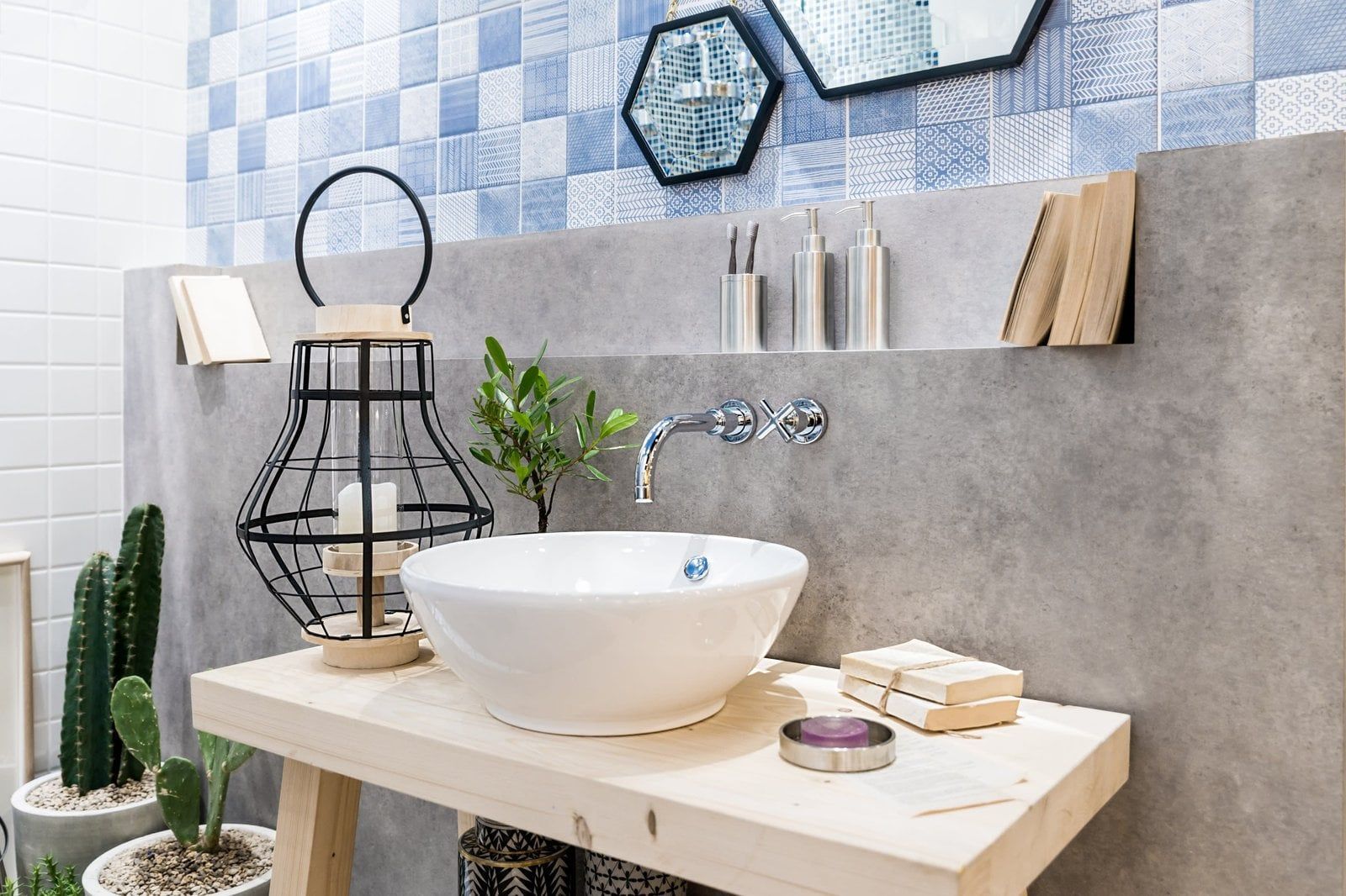 Bathroom with white vessel sink on wooden counter, blue tiled wall, and decorative elements.