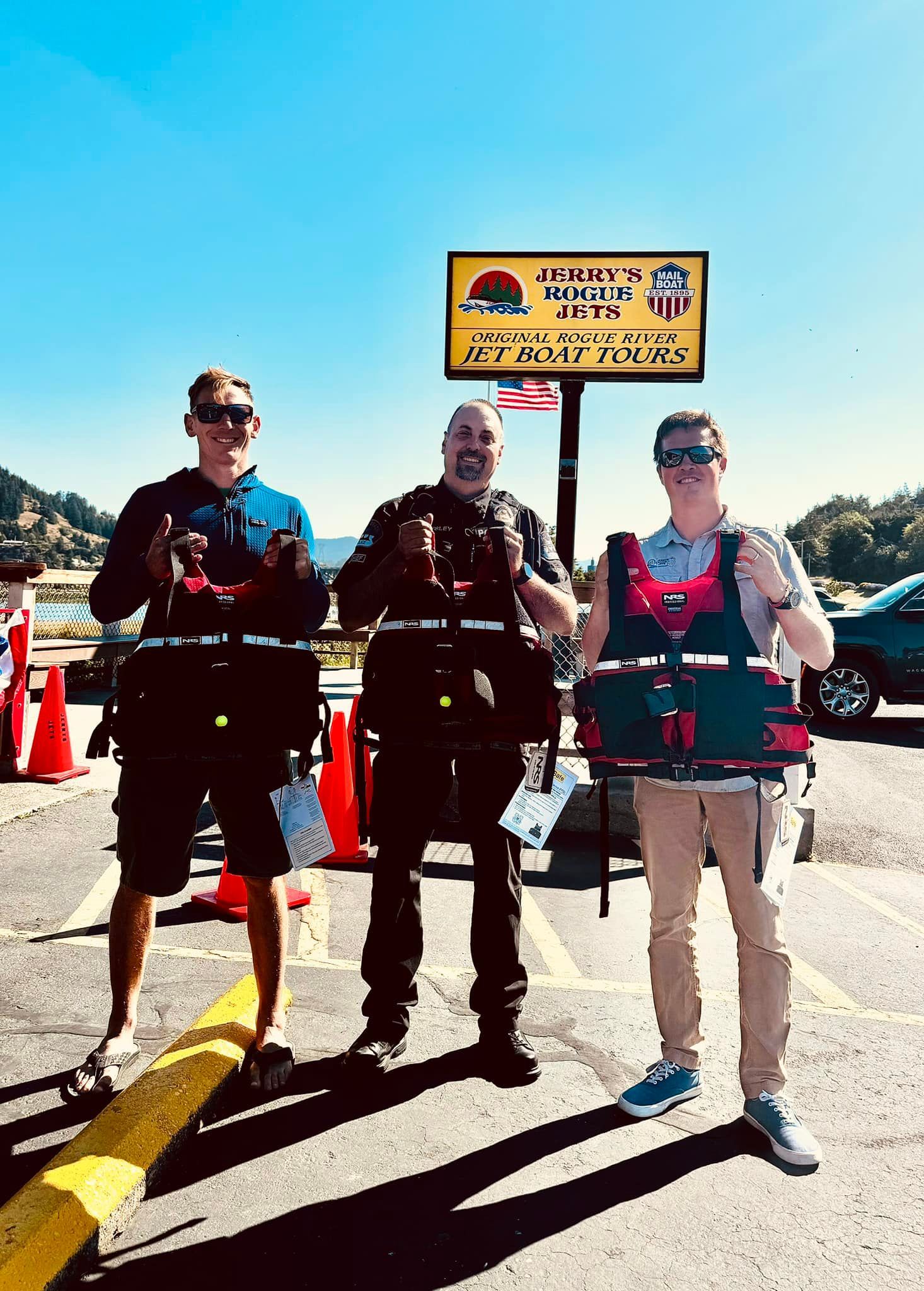 3 people holding life jacket