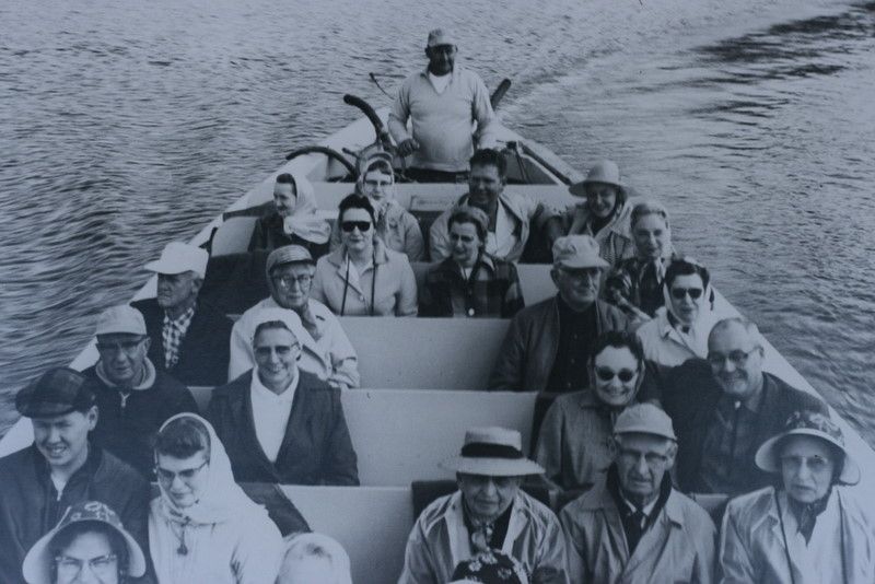 a black and white photo of a boat carrying passengers on the rogue river