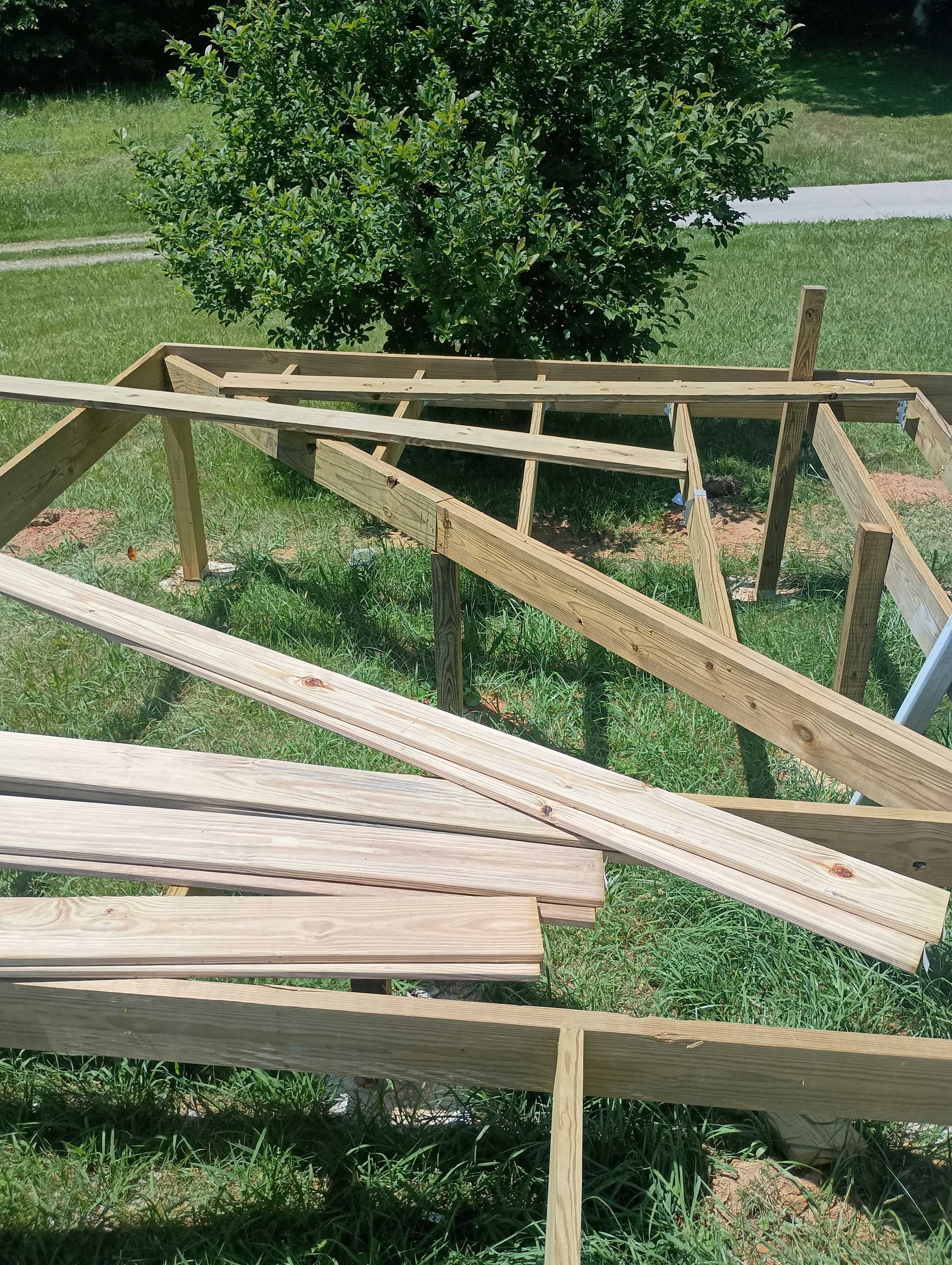 Pile Of Wood Sitting On Top Of A Lush Green Field — Knoxville, TN — DABZ CO LLC Electrical & Building Contractors