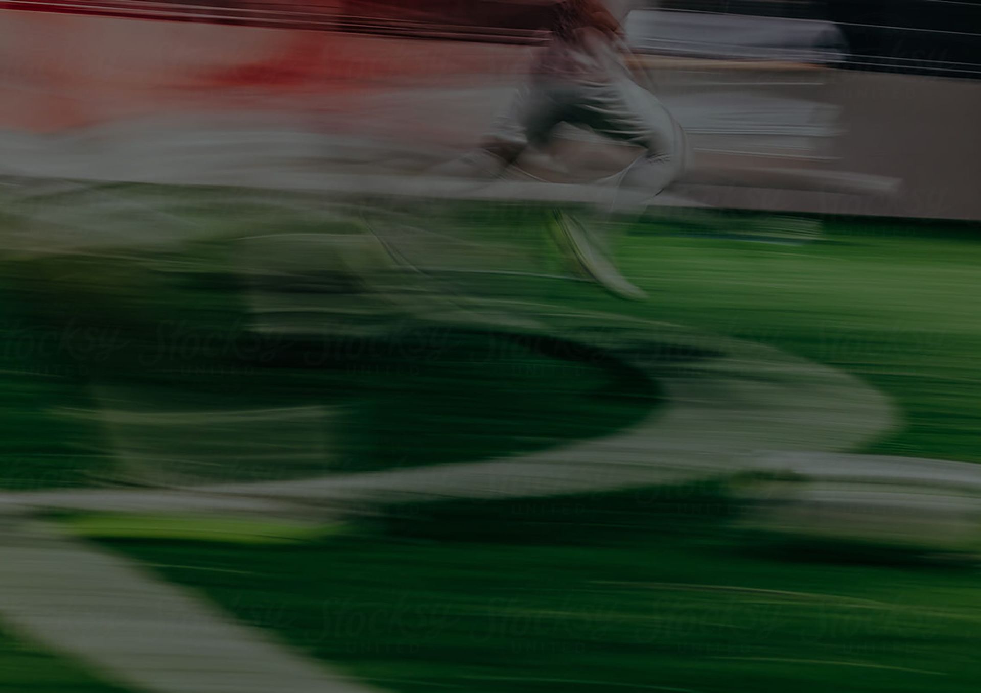 Blurred soccer player in white and black running on a green field during a match