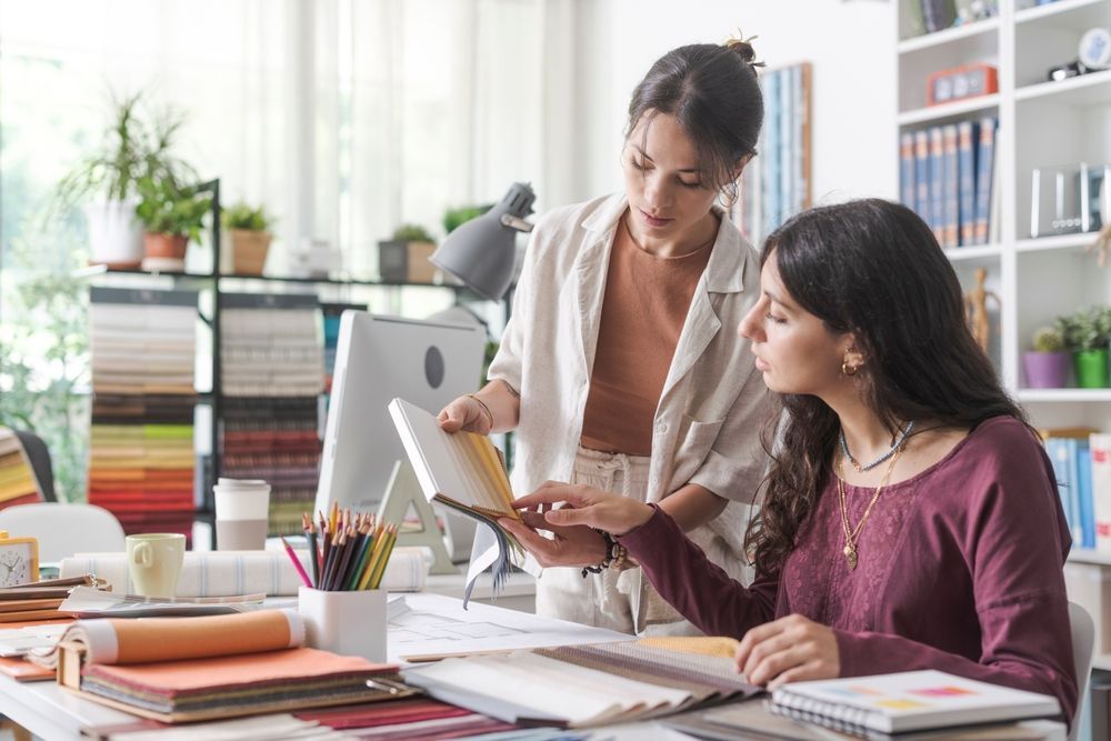 The designer and her employer look over invoices together to discuss Employee Expense Reimbursement Plan.