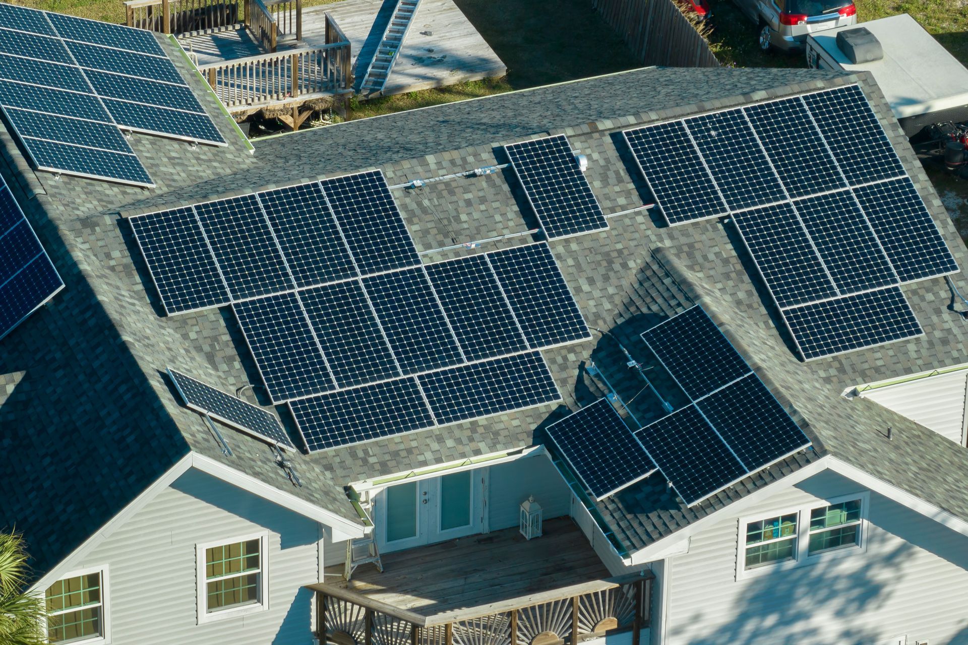 Aerial view of a house roof covered with solar panels on a sunny day
