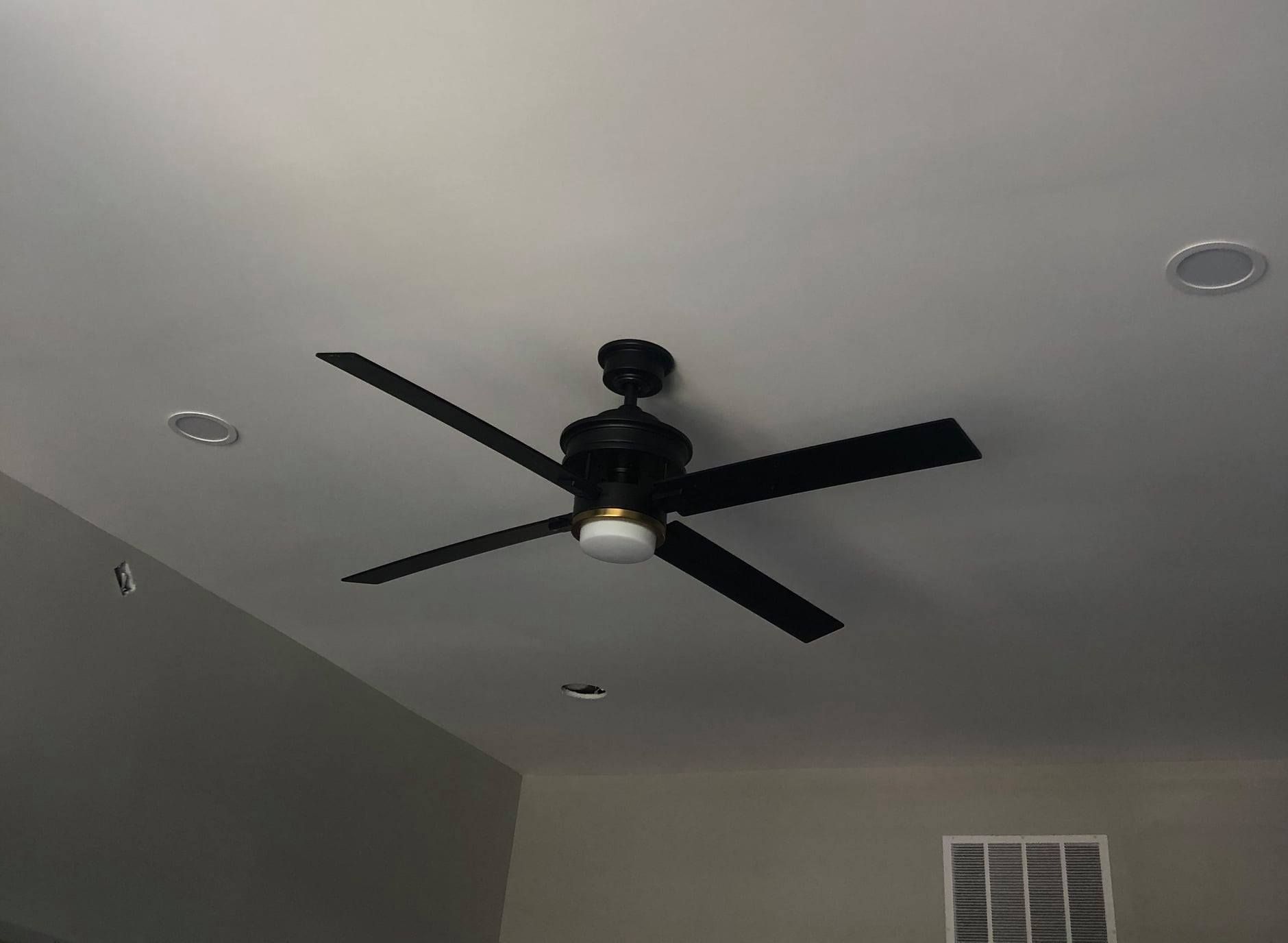 A ceiling fan is hanging from the ceiling of a room.