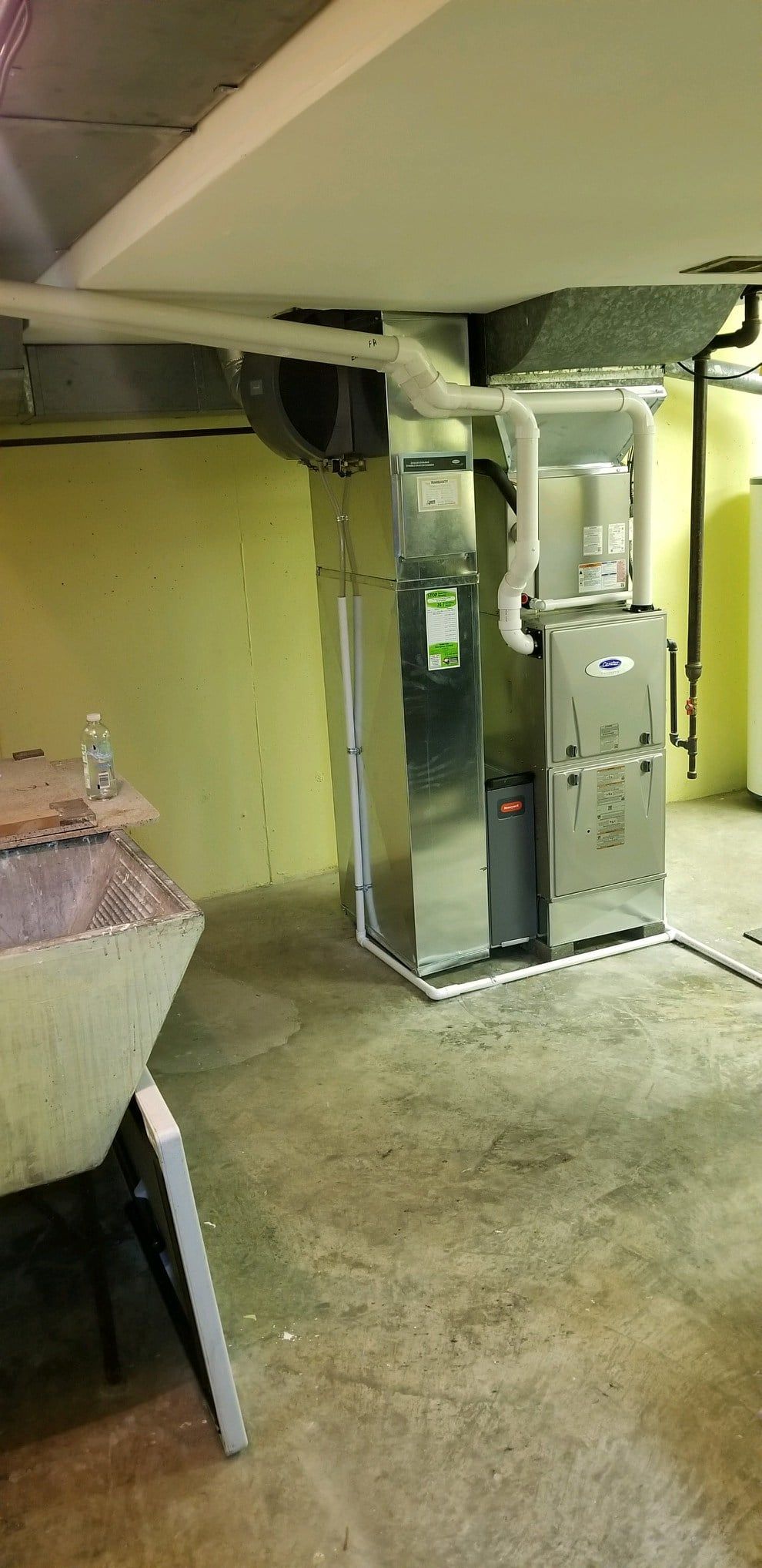 A basement with a furnace and air conditioner in it.