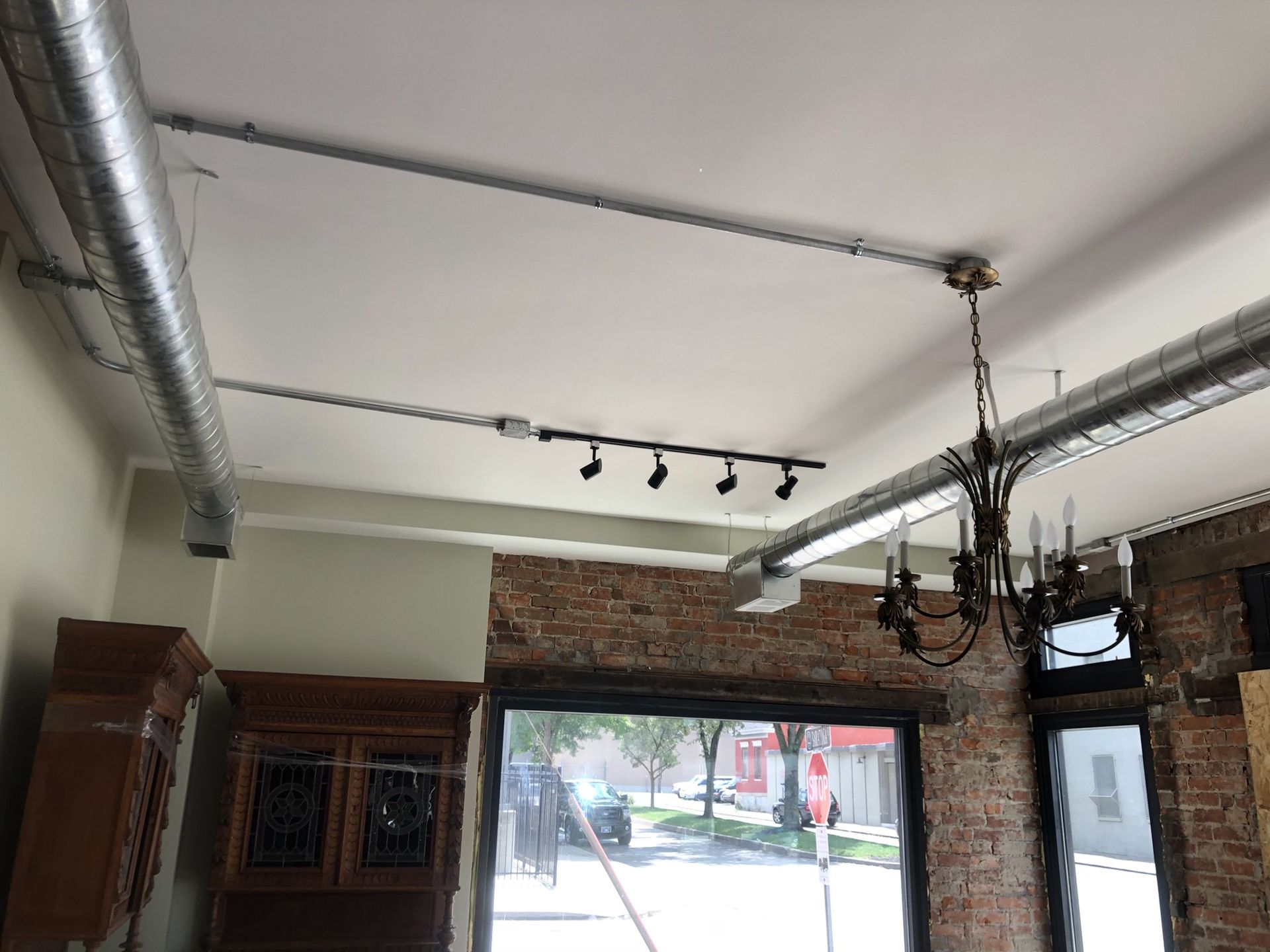 A room with a brick wall and a chandelier hanging from the ceiling.