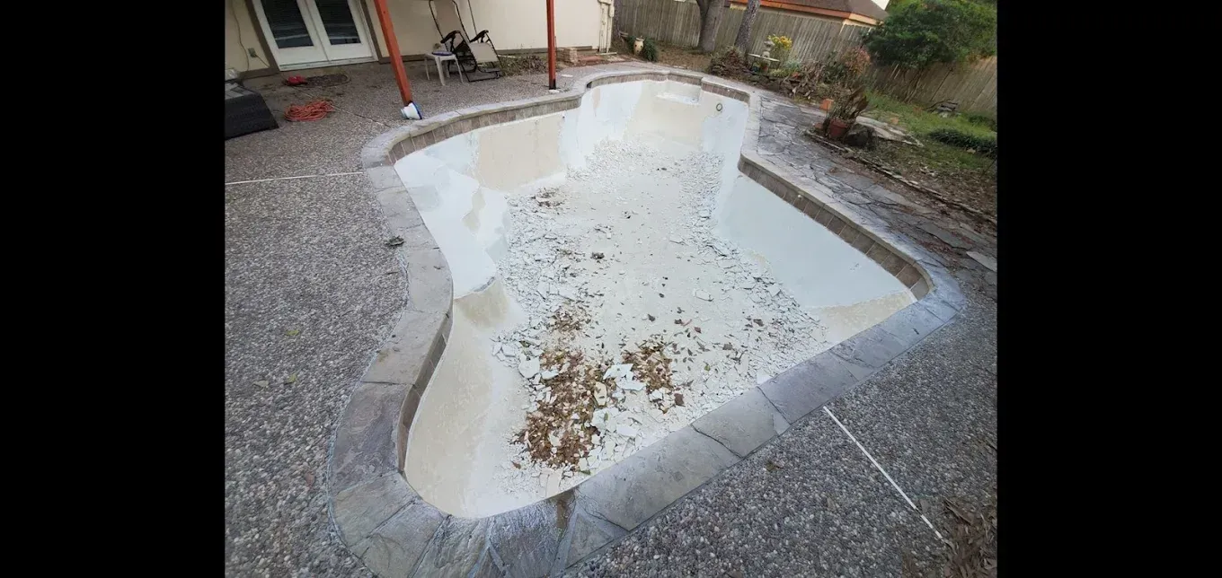 A swimming pool is sitting on top of a concrete patio.