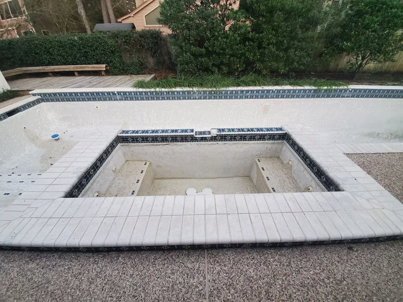 A swimming pool with a jacuzzi in the middle of it