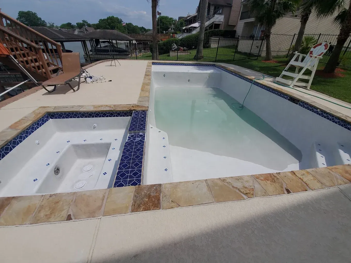 A large swimming pool with a jacuzzi next to it.