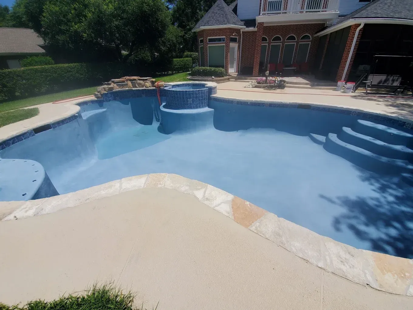 A large swimming pool in the backyard of a house.