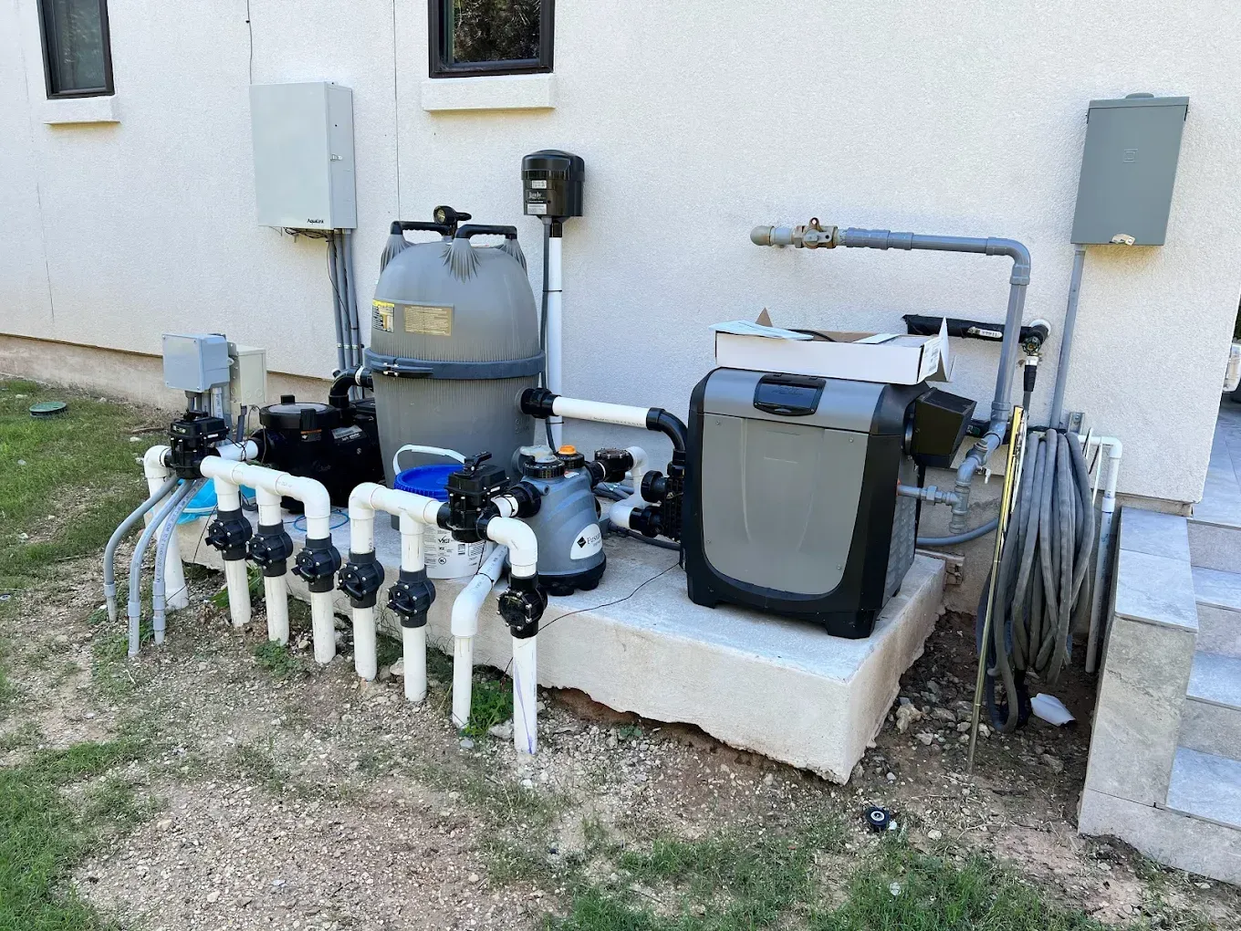 A swimming pool equipment is sitting on the side of a house.