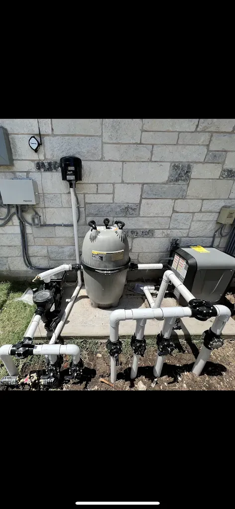 A swimming pool filter is sitting in front of a brick wall.