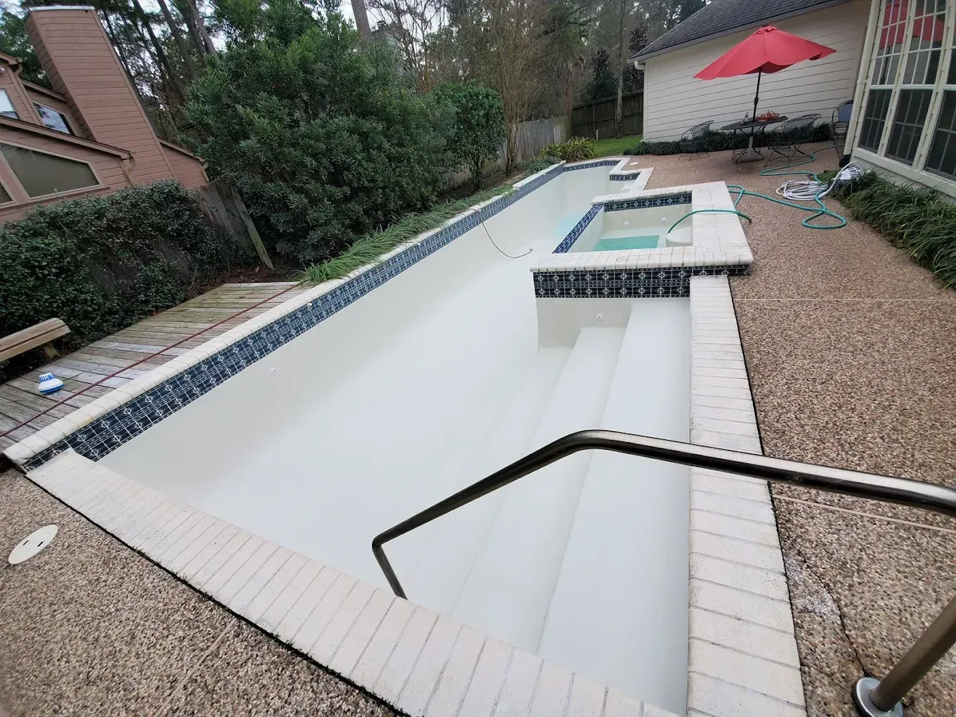 A swimming pool with a red umbrella in the background