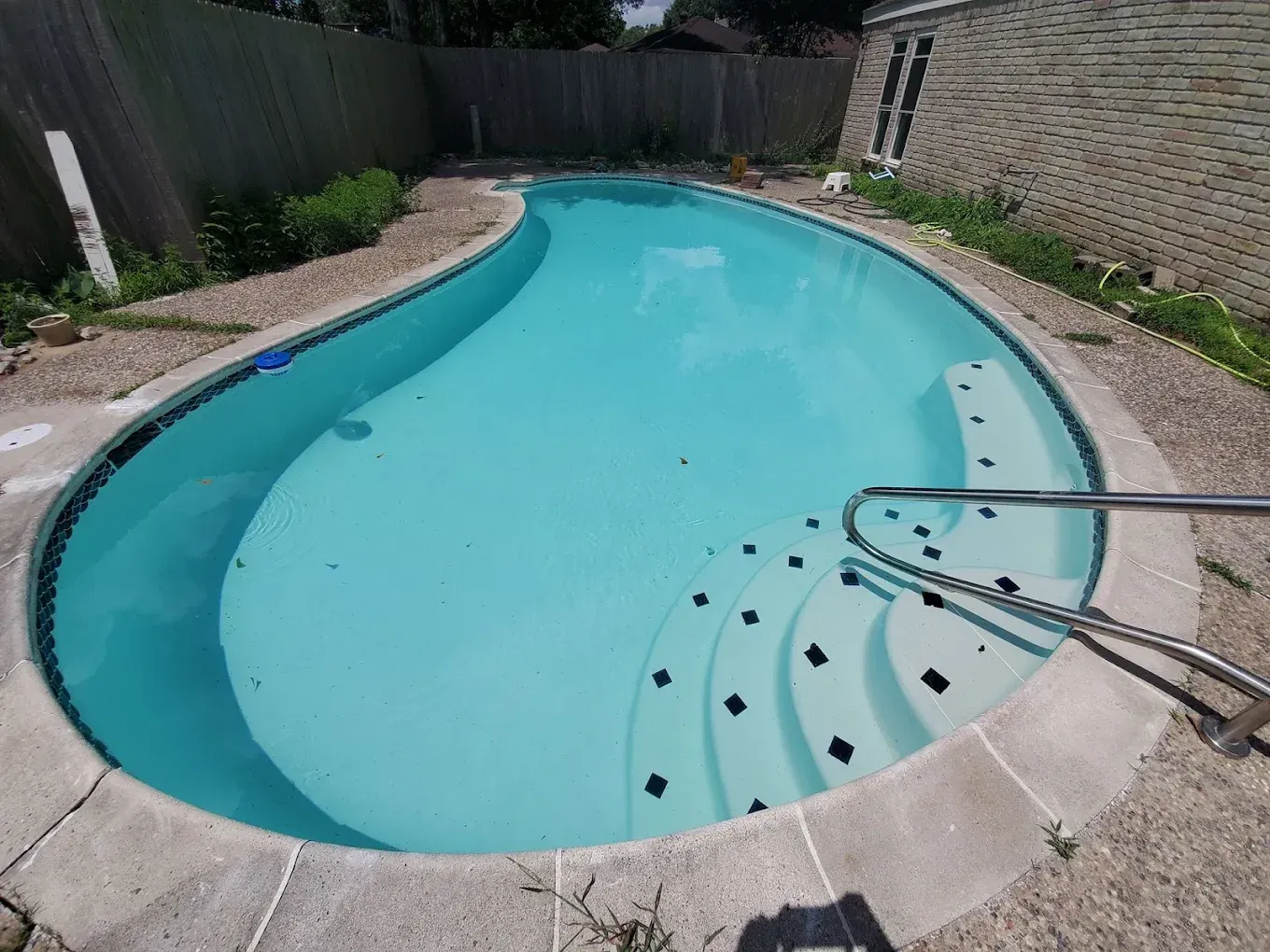 A large swimming pool with stairs leading to it