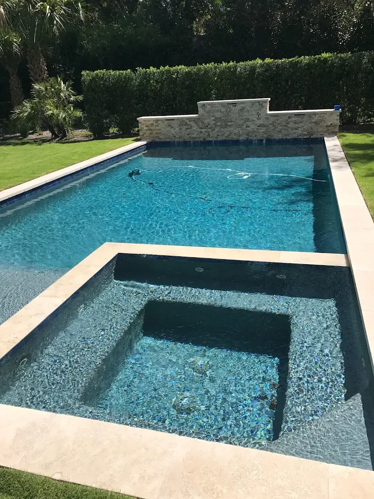 A large swimming pool with a hot tub in the middle of it.