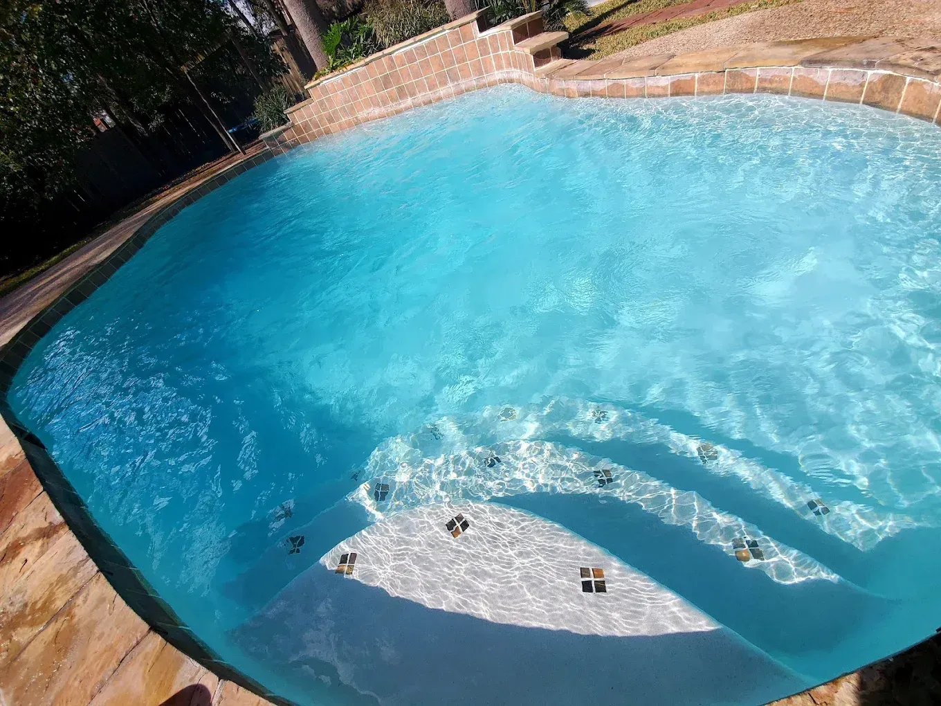 A large swimming pool with stairs leading into it
