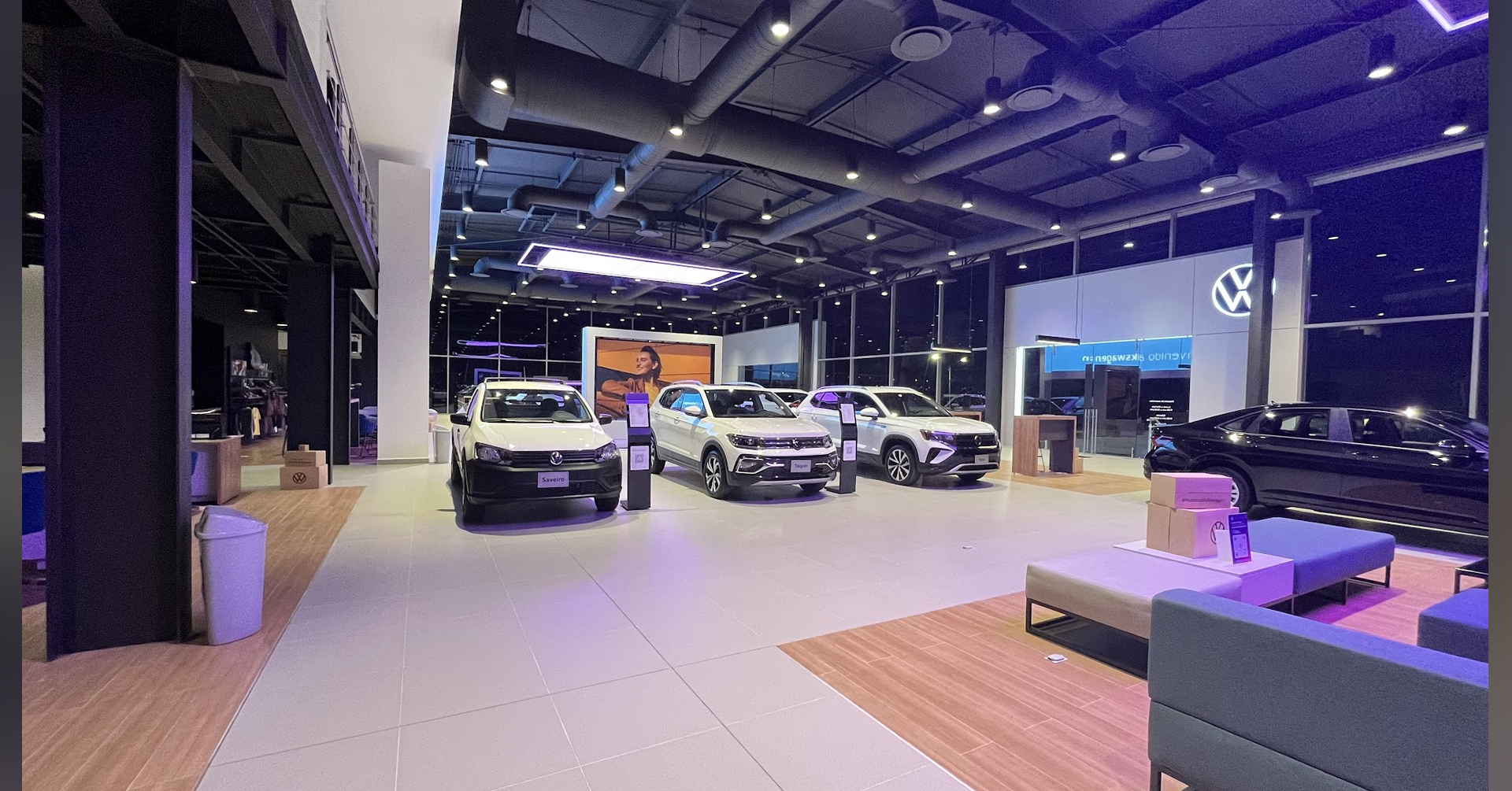 Un concesionario de coches con muchos coches y un sofá.