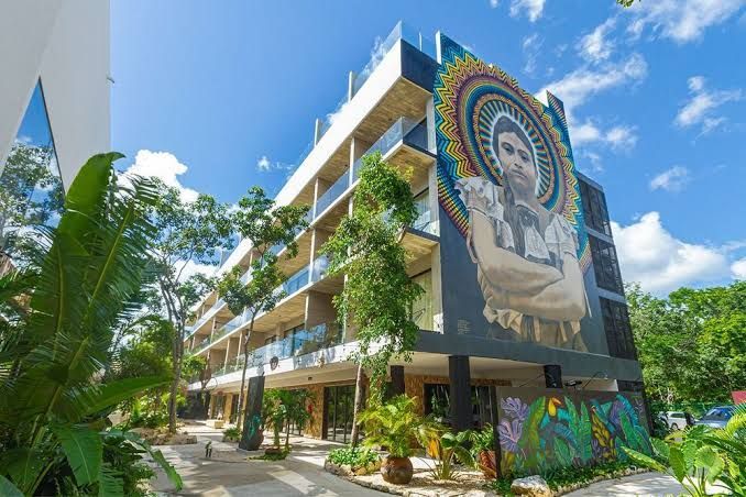 Un edificio grande con un mural al costado.
