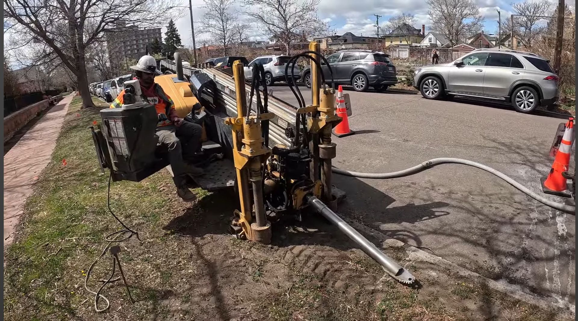 Hand plugging an Ethernet cable into the back of a white router with other colored cables connected.