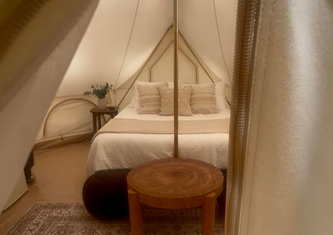 A kitchen with a sink , stove , microwave and stairs leading to the second floor.