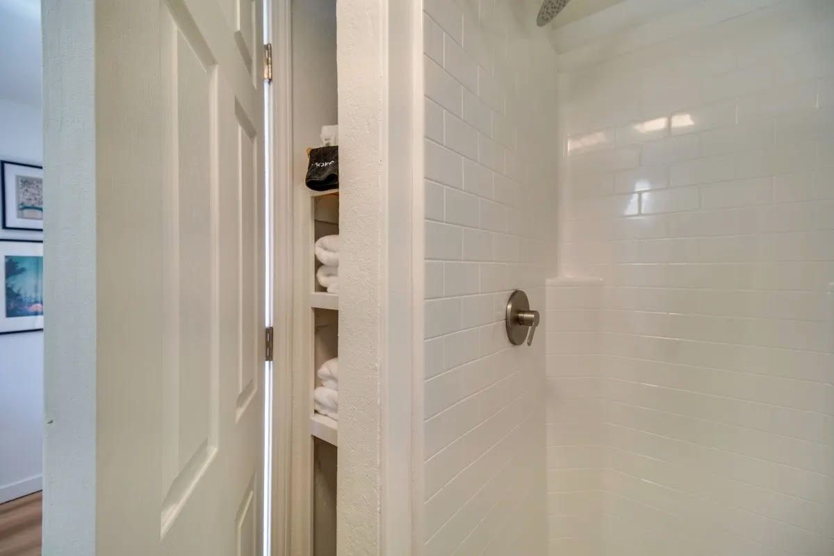 A bathroom with a shower and a closet.